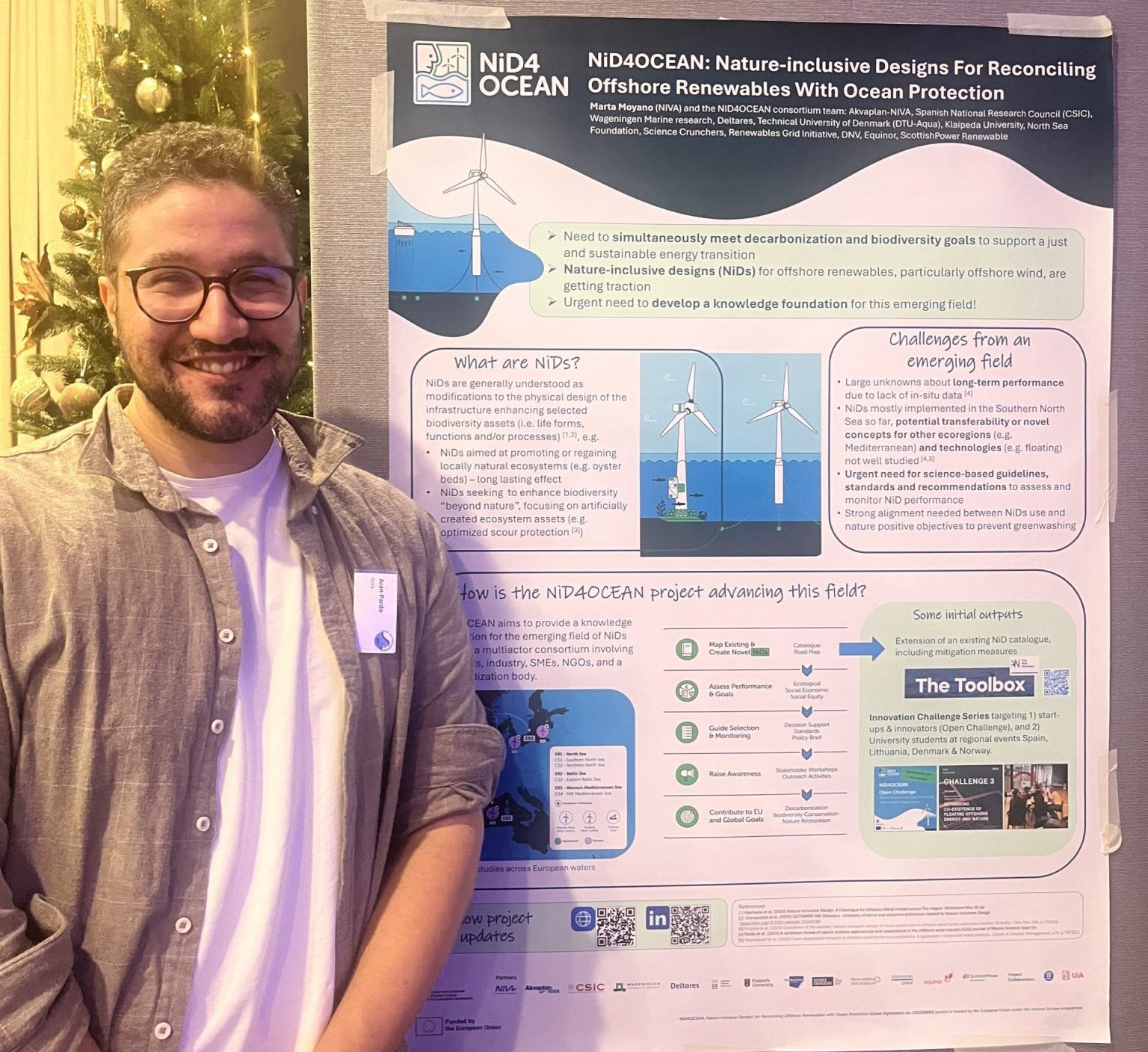 Juan Parto standing next to the NiD4OCEAN project presentation poster