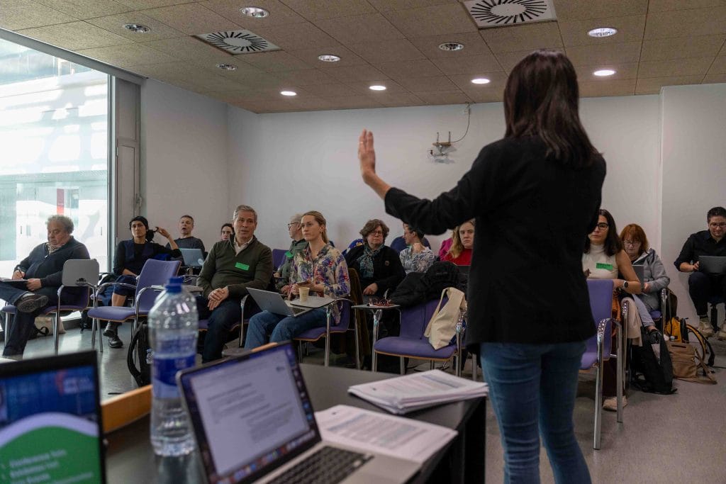Presentations during the 4th NiD4OCEAN consortium meeting - a room with all the partners sitting in chairs, presentar is standing back to the camera